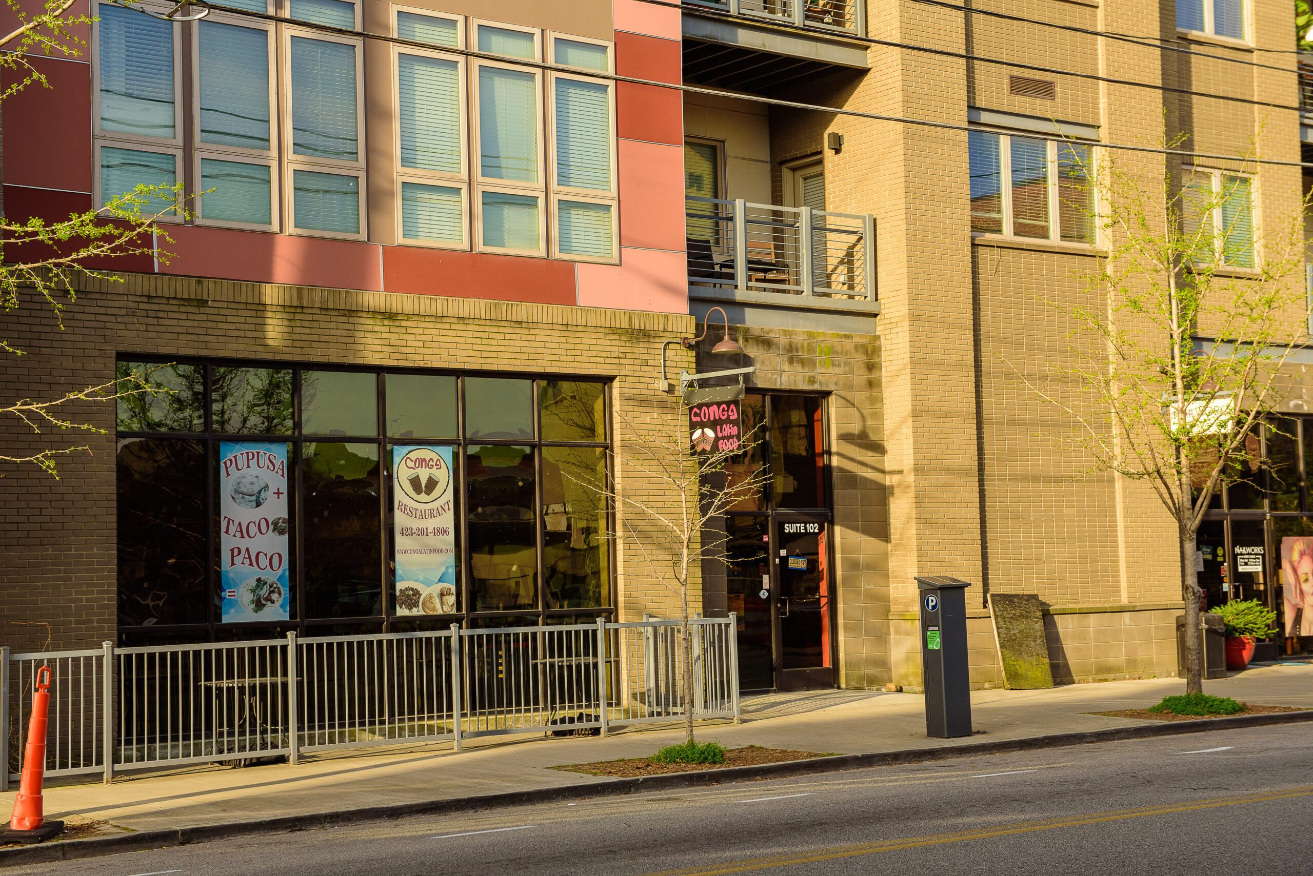 The Main Street frontage with storefront glazing, street trees and on-street parking