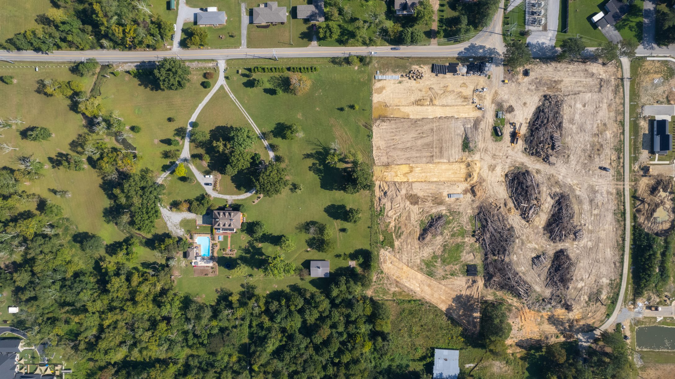 Overhead view of the cleared site next to an intact wooded property