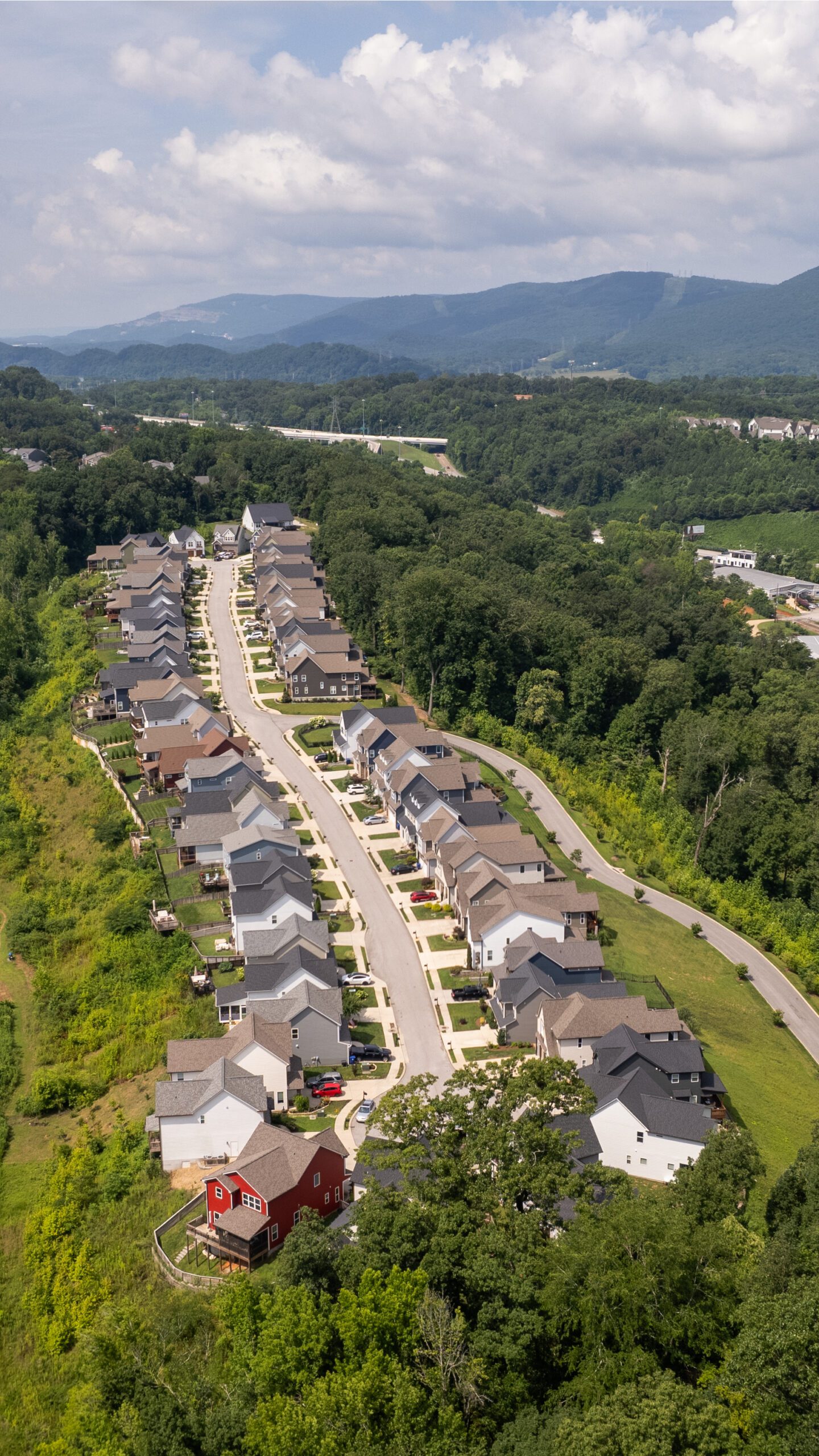 Aerial view down the length of the Northpoint Ridge street, with homes lining both sides of the ridgetop and the valley and mountains beyond