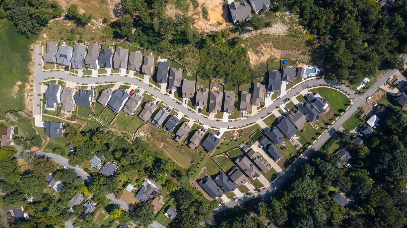 Overhead aerial of the neighborhood showing the curving street and lot layout