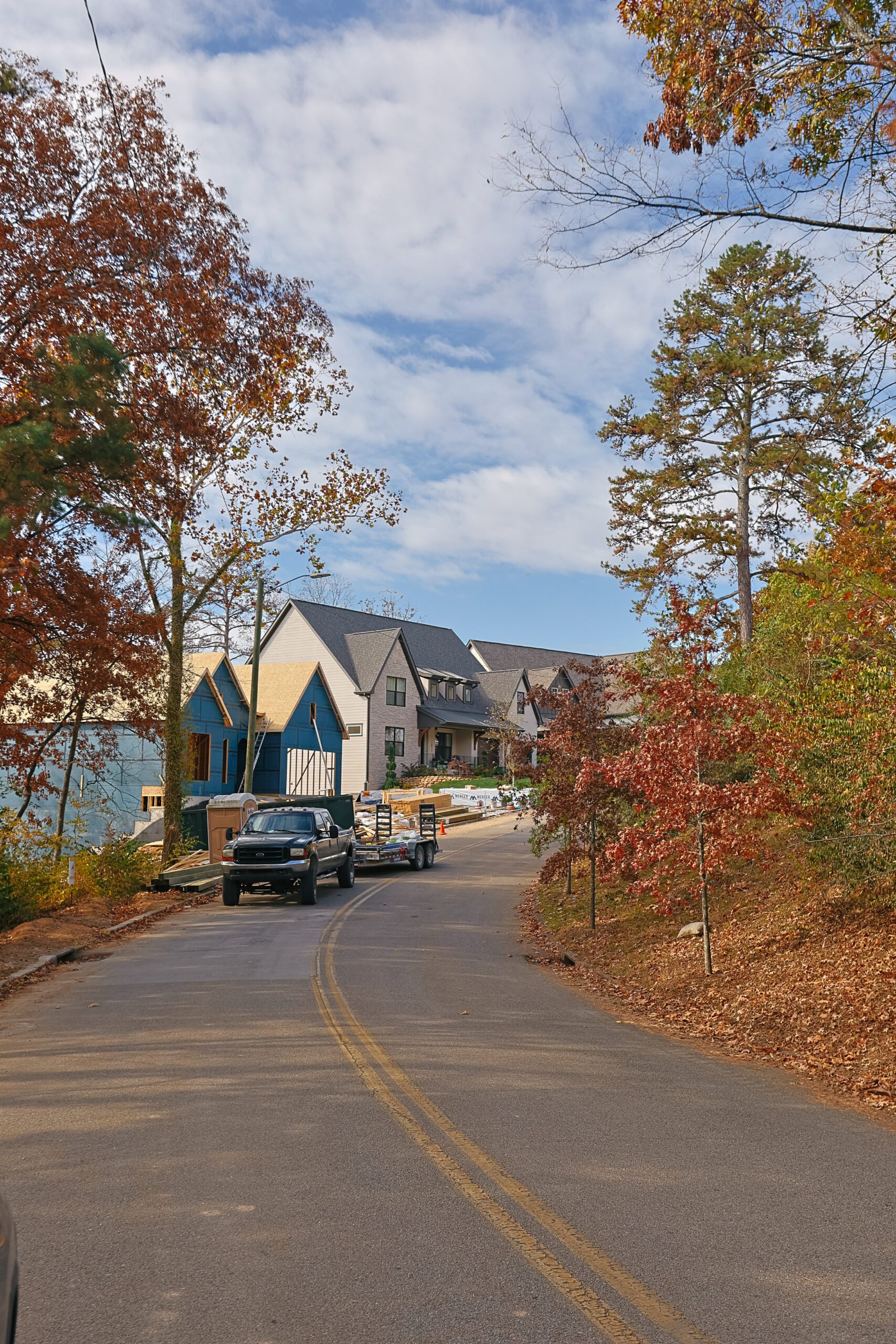 Neighborhood street with sidewalk, driveways and street trees