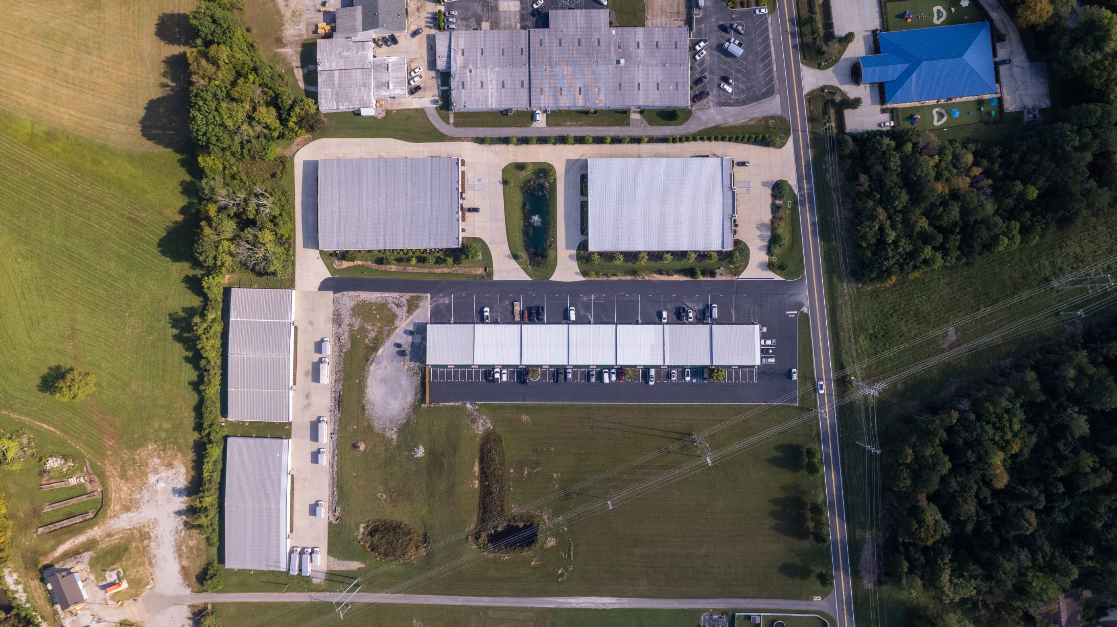 Overhead aerial of the full Rhodes Storage site with buildings, parking and pond