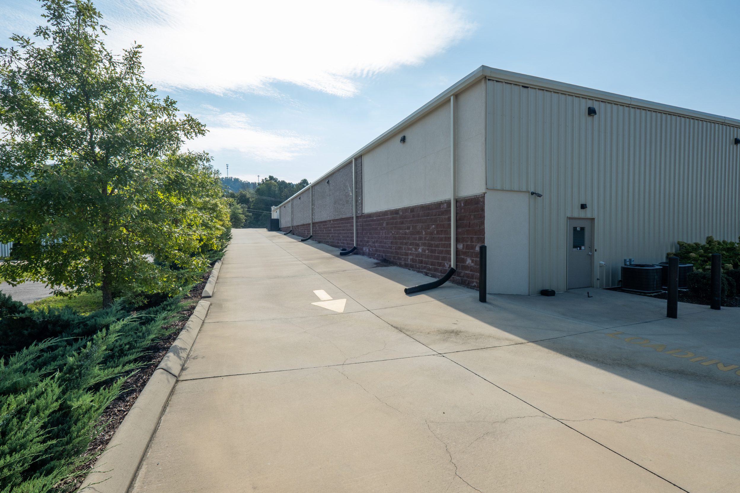 Concrete drive running the length of the storage building with downspouts discharging to grade